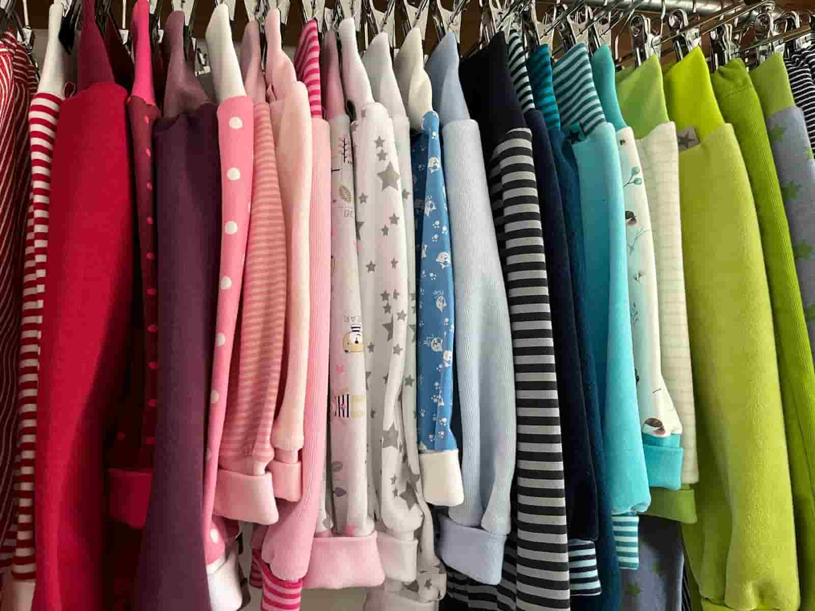 Kleiderständer mit bunten Kinderhosen, von Pink über Blau bis Grün sortiert