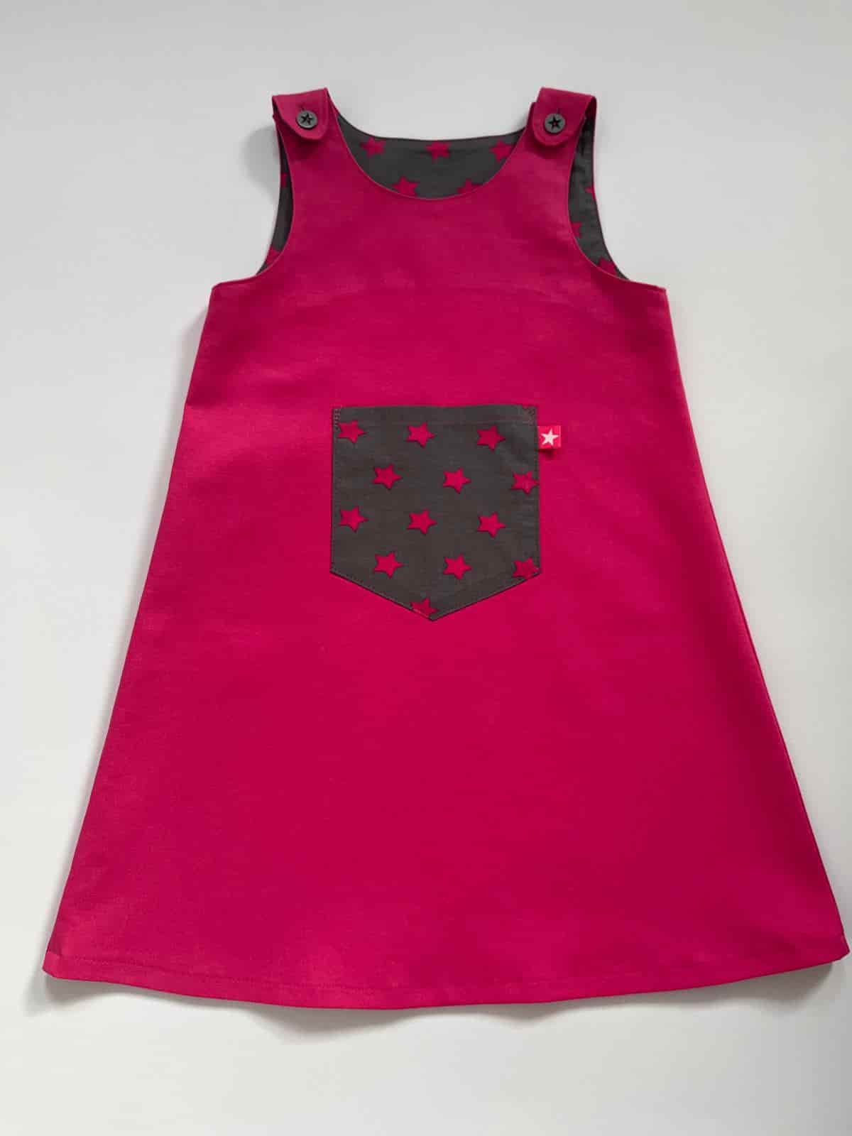 Pinkes Trägerkleid mit grauer Sterntasche und Sternknöpfen